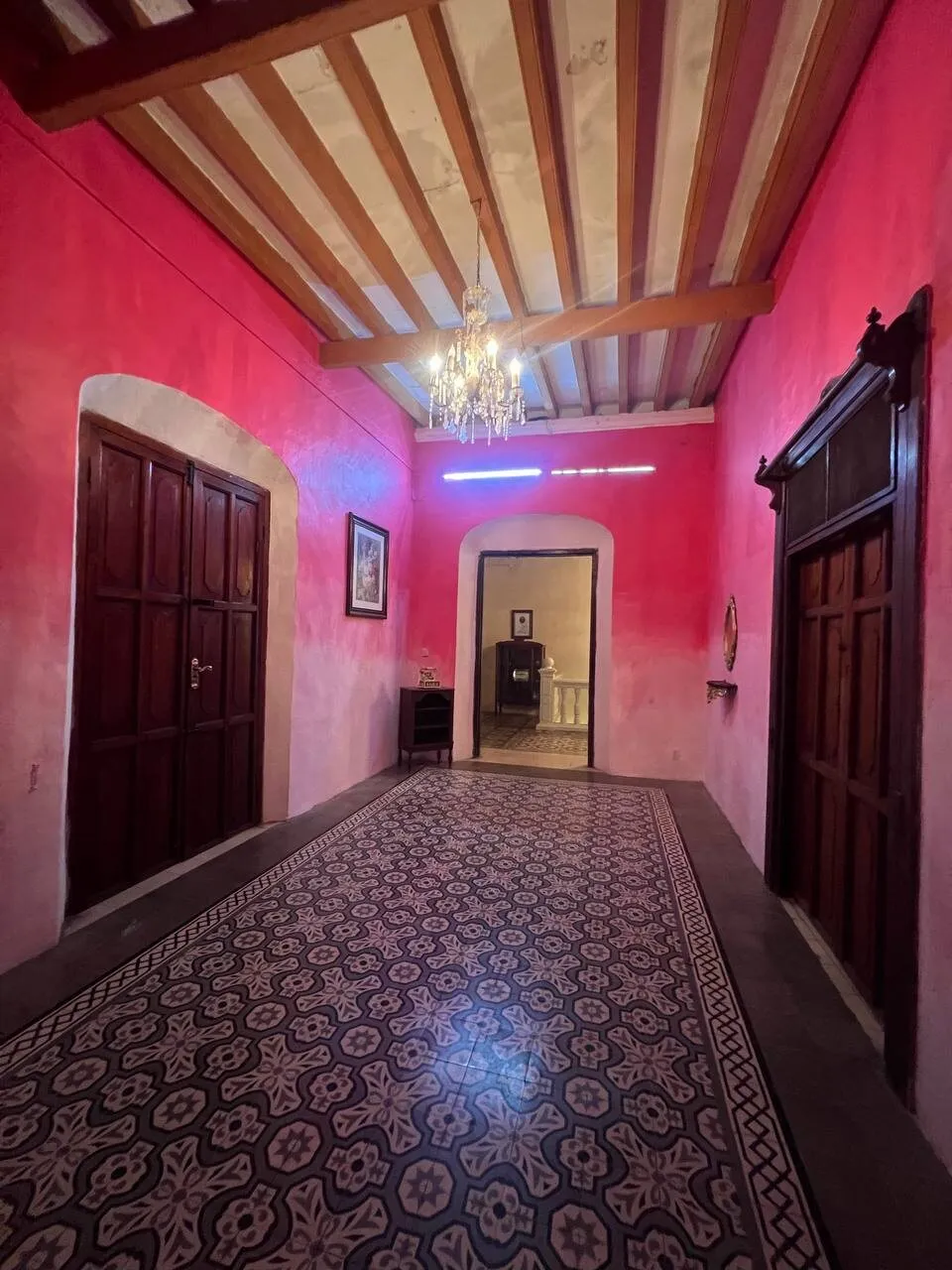 Corredor de muros rosas con vigas de madera