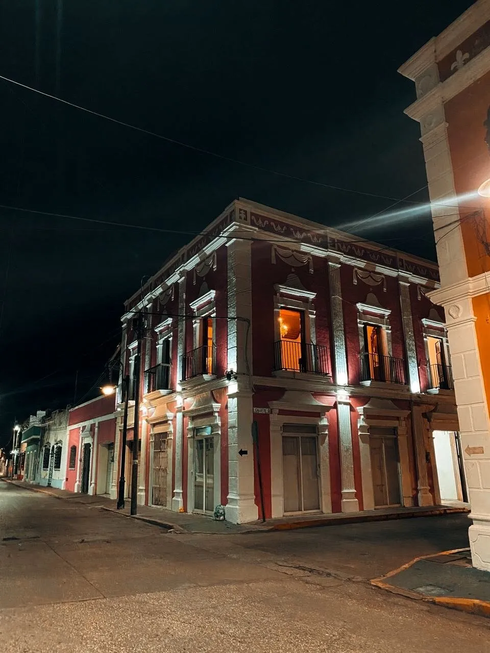 Fachada de Casa Estrella iluminada de noche, en la esquina de las calles 24 y 25